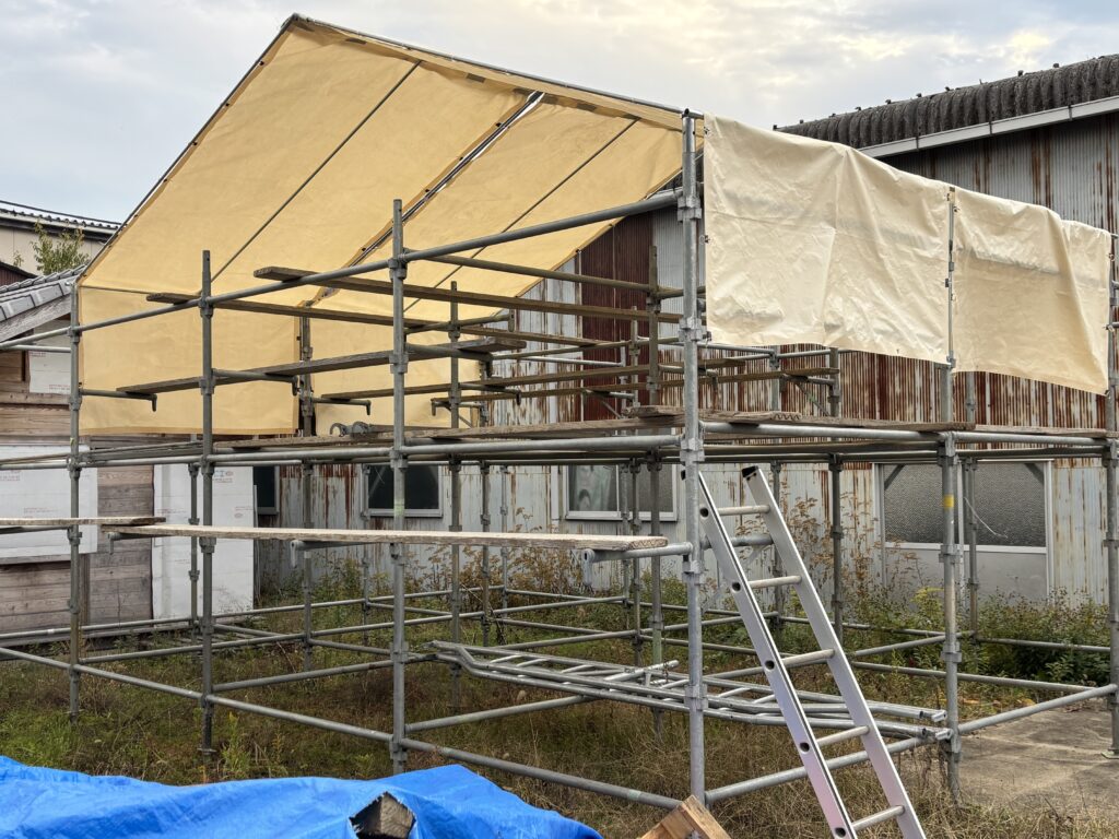 滋賀で屋根工事を行う株式会社丸由が導入する、建築現場の快適化を実現する日よけ・雨よけシート付き足場設備