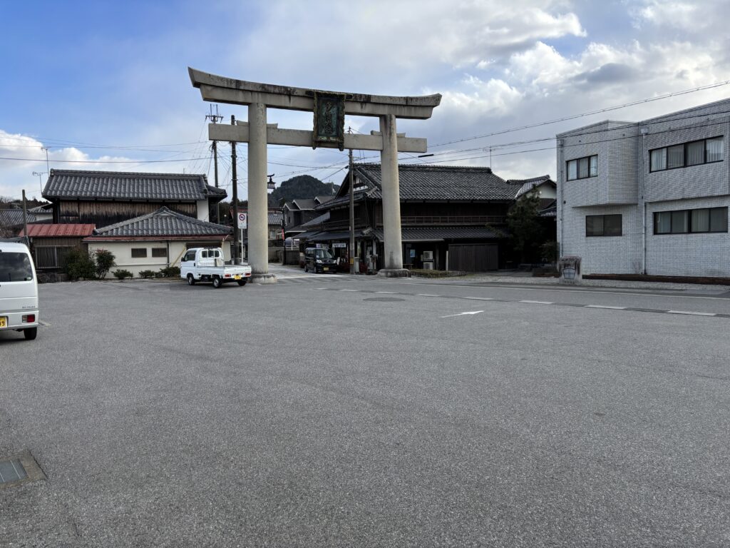 多賀大社前駅前に立つ大鳥居。背景には和風建築の町並みが広がっている。