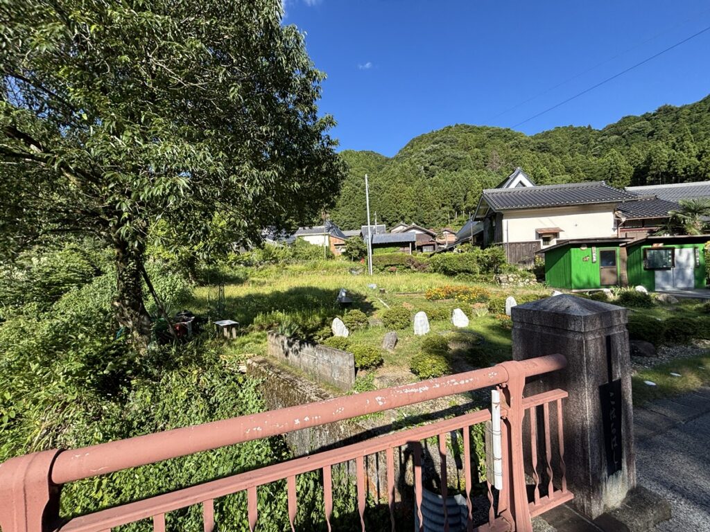 多賀永源寺線沿いの前面道路から見た多賀町の空き地。周囲は緑豊かな住宅地。