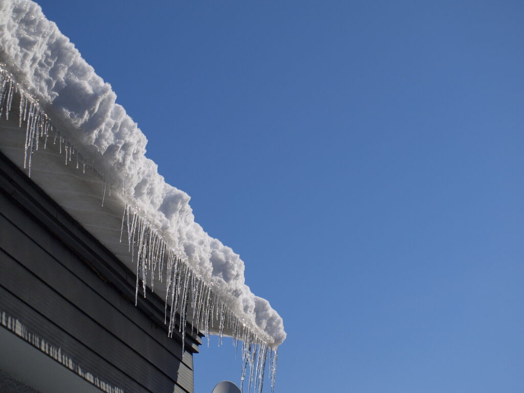 雪とつららが積もった住宅の屋根の様子