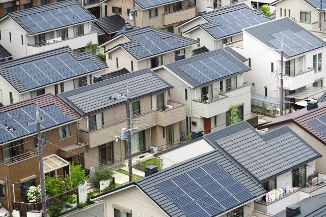 住宅街の屋根に設置された多数の太陽光パネル