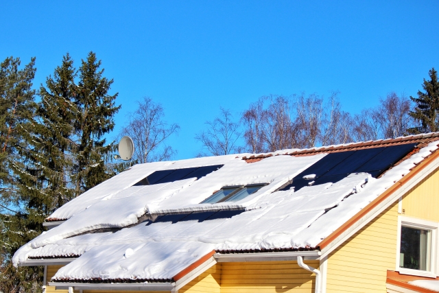 雪が積もった屋根に設置された太陽光発電パネル
